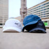 ART print on white, black, and jeans coloured cap.